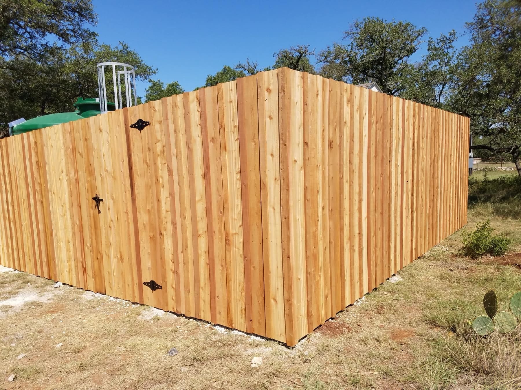 A new board-on-board cedar privacy enclosure with iron hinges